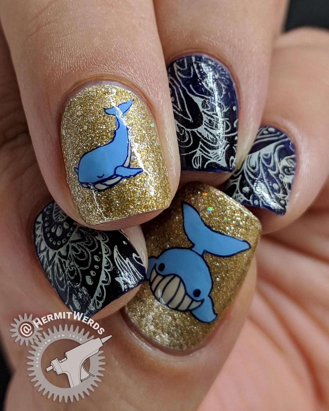 Paisley Whale - Hermit Werds - nail art with a dark blue and cream paisley pattern and two glittery gold whale accent nails