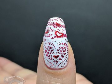 Lacy Heart - Hermit Werds - lace stamping in a heart shape over a glittery pink background with red heart sequins on top