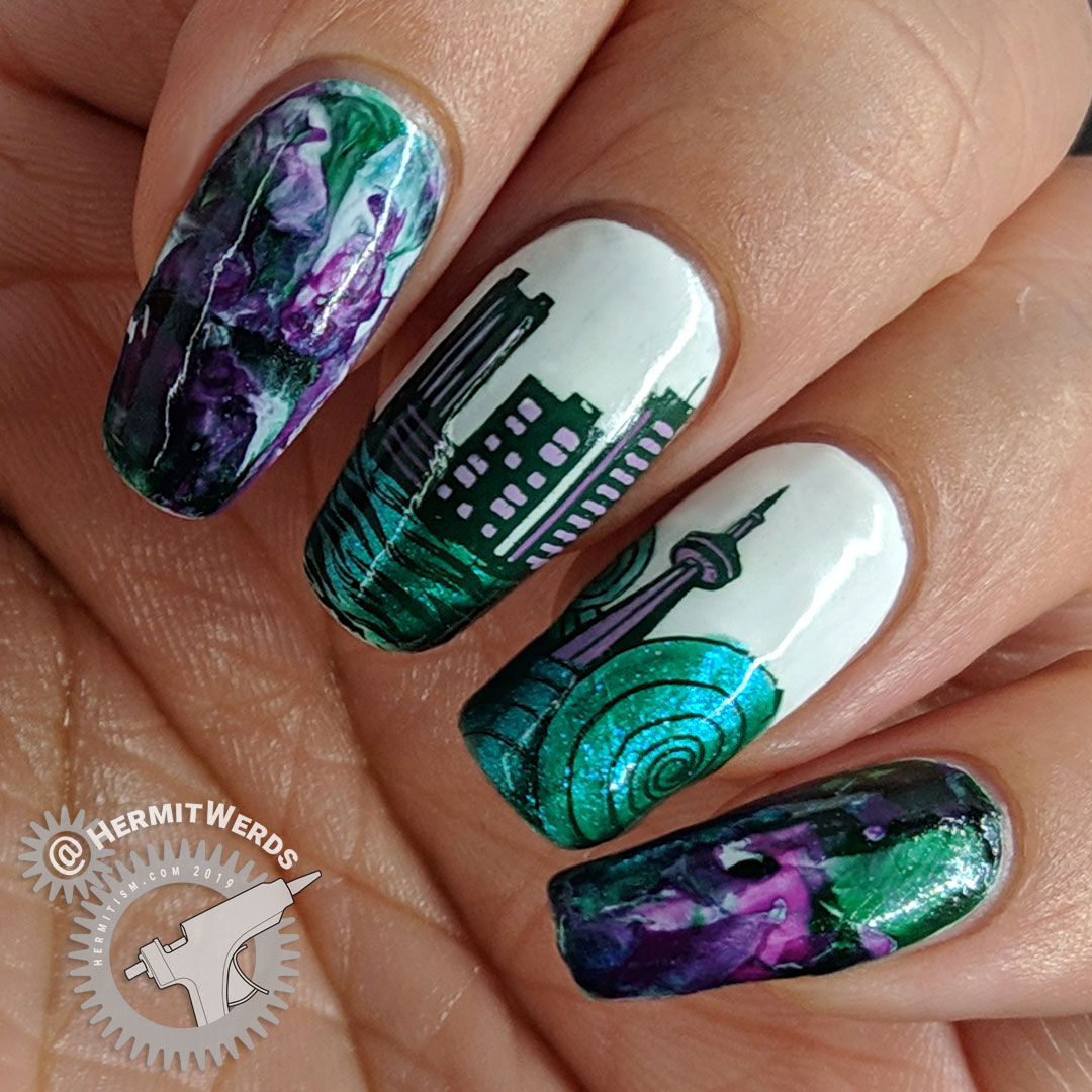 Nail art for Seattle with a cityscape and the Space Needle bracketed with a smoosh marble in emerald green and purples.