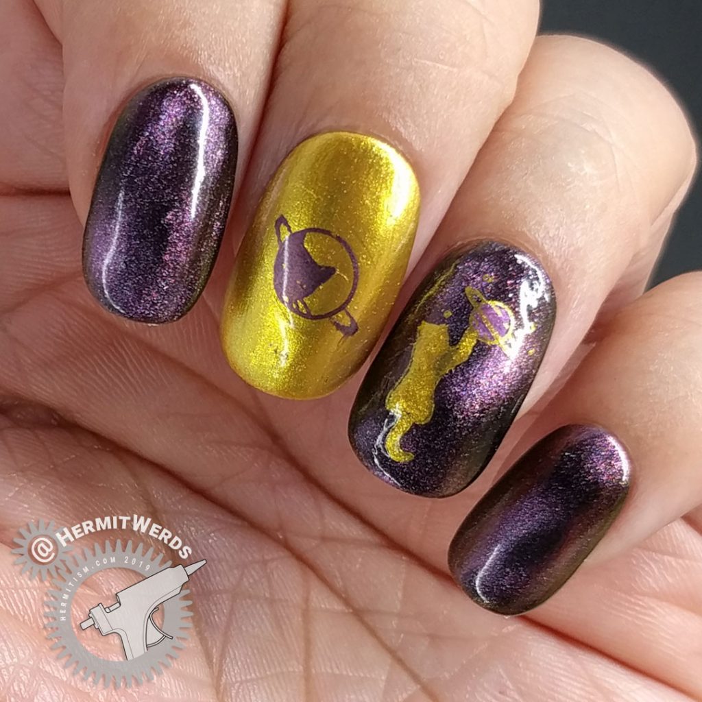 Purple/pink magnetic polish with golden space cats stamped on top.