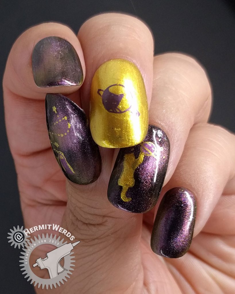 Purple/pink magnetic polish with golden space cats stamped on top.