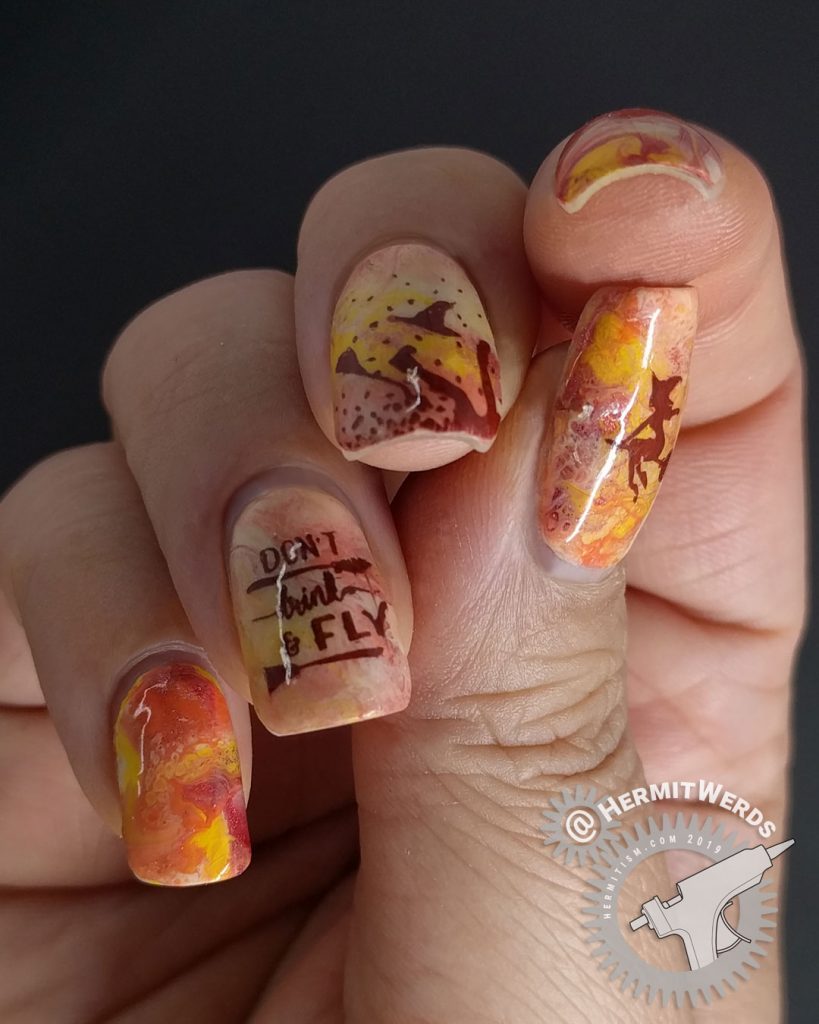 Orange, yellow, and coral fluid art nails with witch nail art stamped on top. Don't drink and fly!