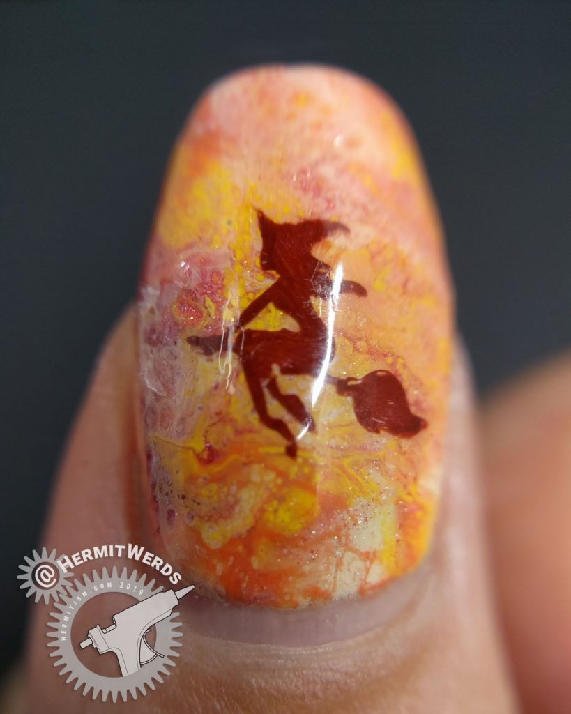 Orange, yellow, and coral fluid art nails with witch nail art stamped on top. Don't drink and fly!