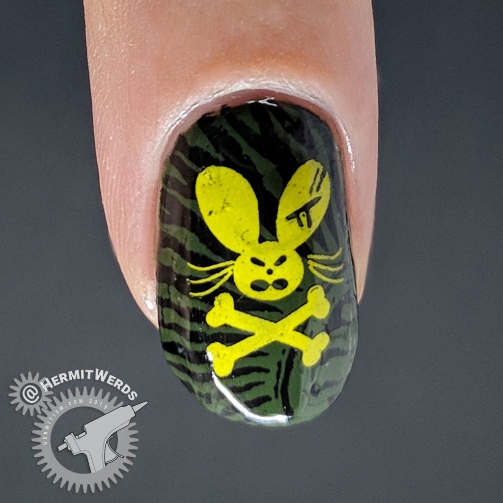 Olive green nail with creepy pattern and ocre pirate rabbit.
