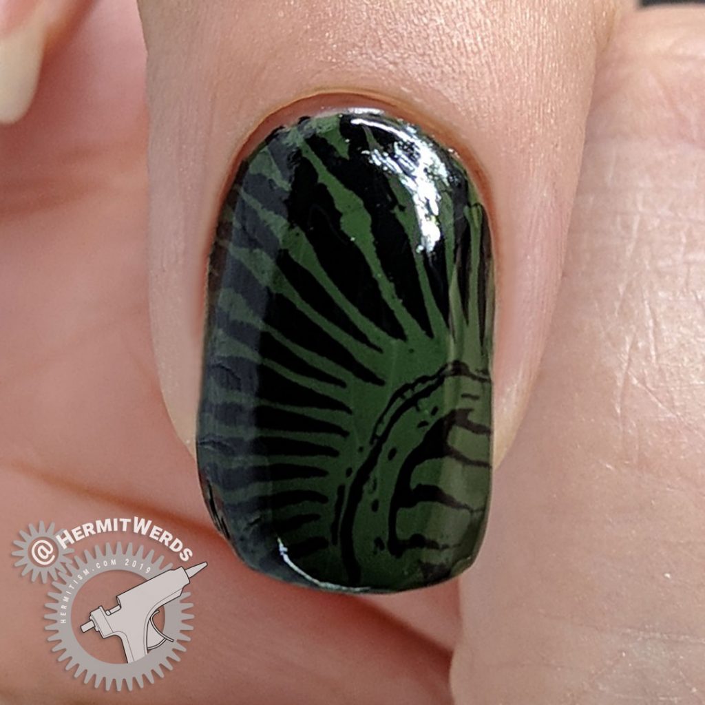 Olive green nail with creepy pattern.