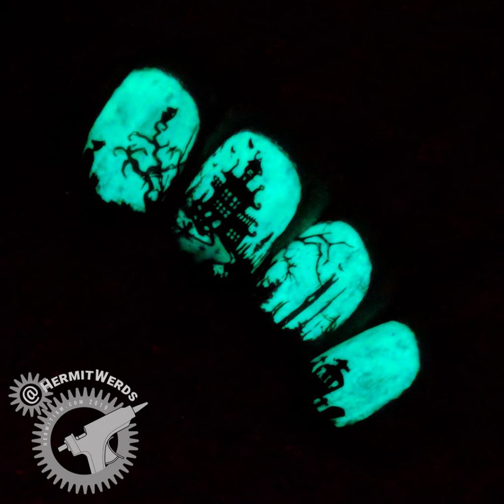 Glow in the dark haunted graveyard nail art with overlooking castle.