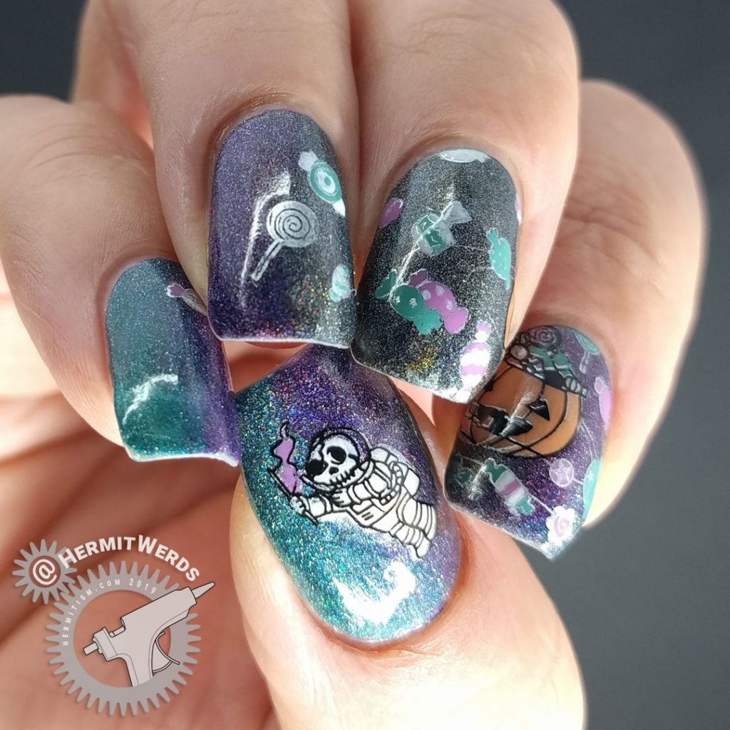 Black, purple, and teal holographic galaxy nail art with Halloween jack-o-lantern planet and space candy.