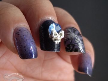 Blurple thermal nail art with skulls and skeletons and a blue and silver rhinestone.