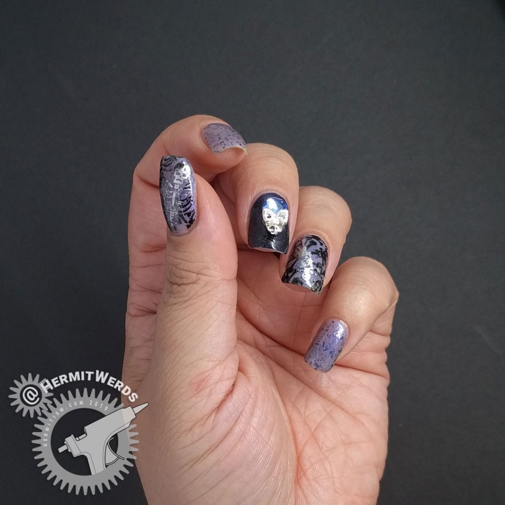 Blurple thermal nail art with skulls and skeletons and a blue and silver rhinestone.