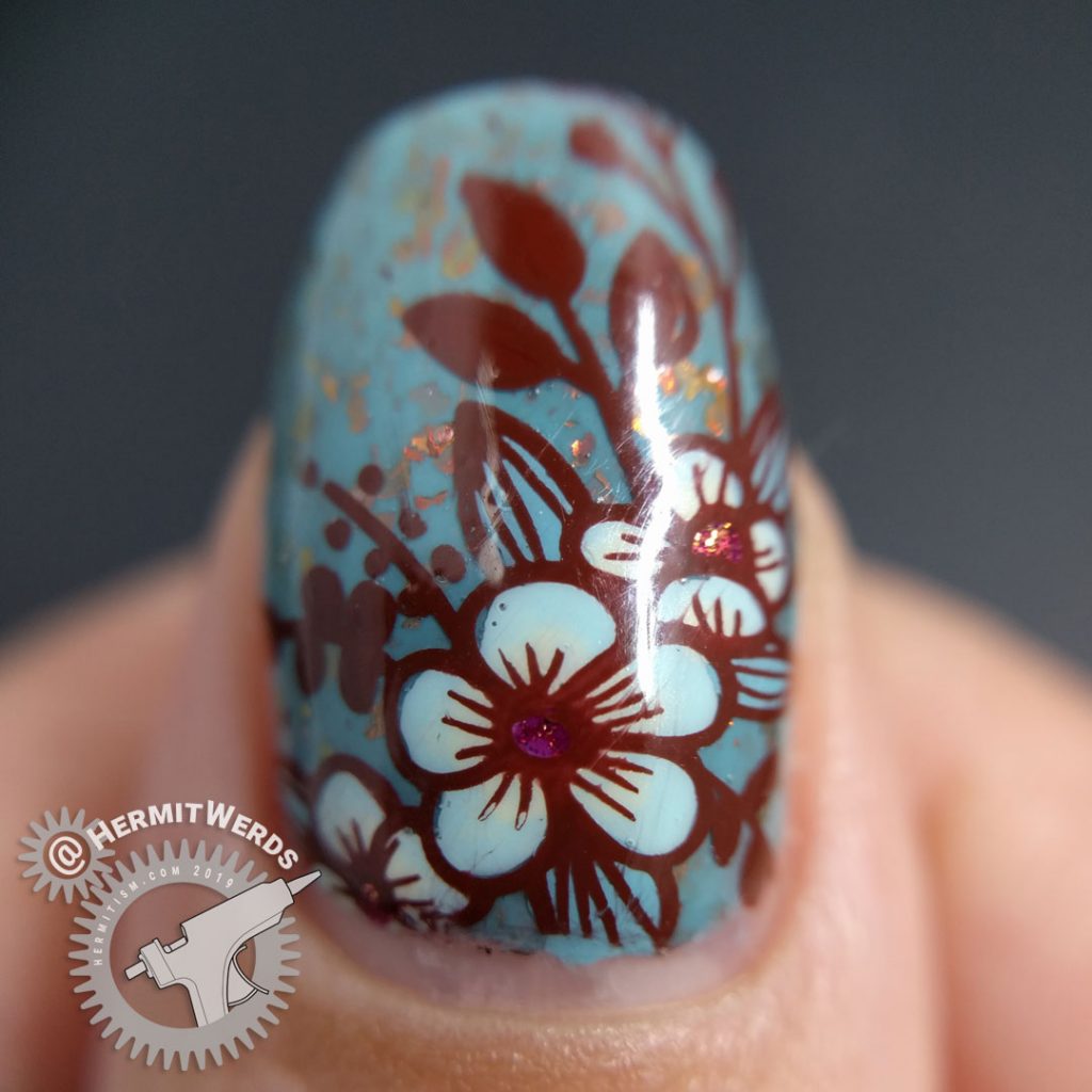 Autumnal nail art with a little blue bird against a robin blue crelly full of pink/orange/red flakies.
