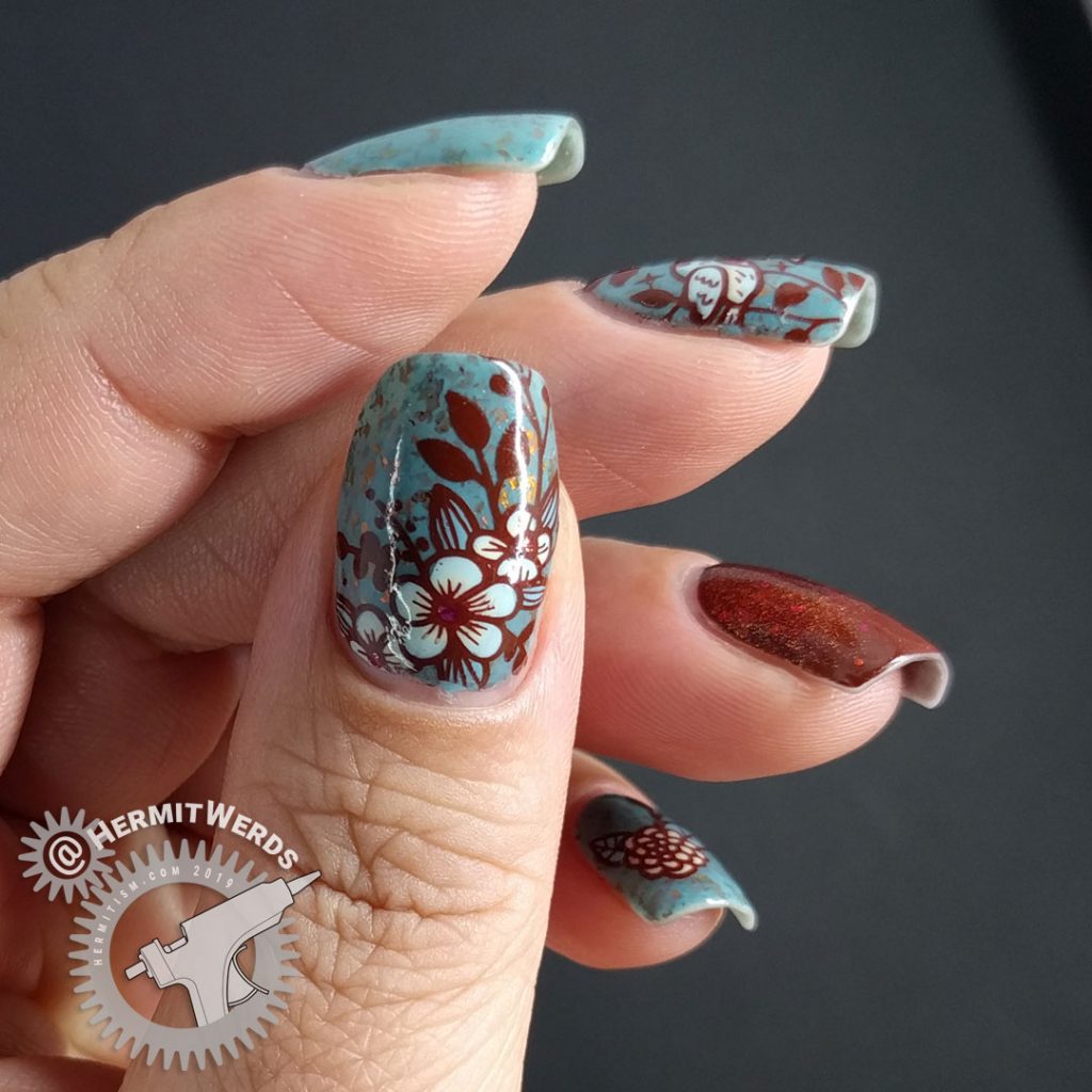 Autumnal nail art with a little blue bird against a robin blue crelly full of pink/orange/red flakies.