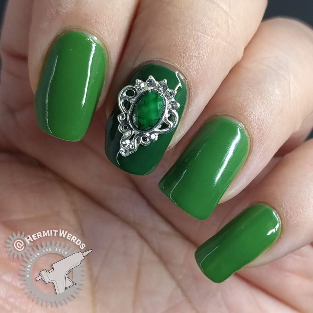 Super green nail art with a silver and green nail charm.
