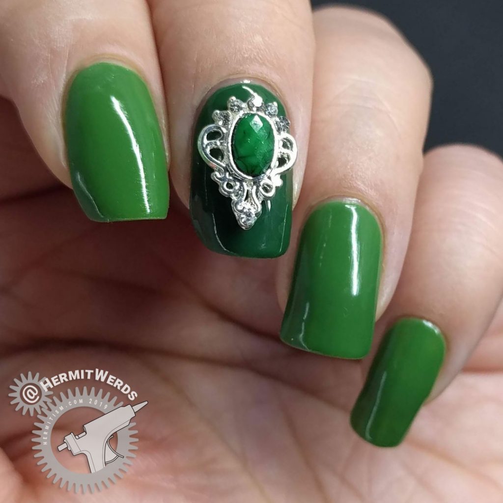 Super green nail art with a silver and green nail charm.