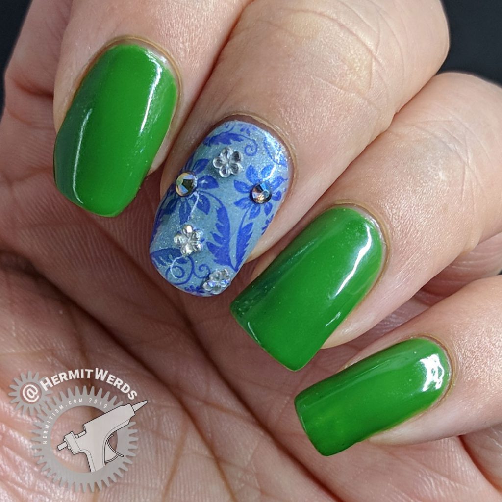 Floral nail art featuring Pantone's Eden and blue floral accent nails with rhinestones.