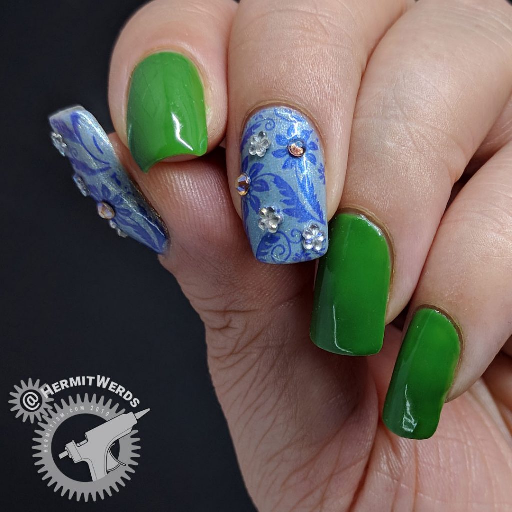 Floral nail art featuring Pantone's Eden and blue floral accent nails with rhinestones.