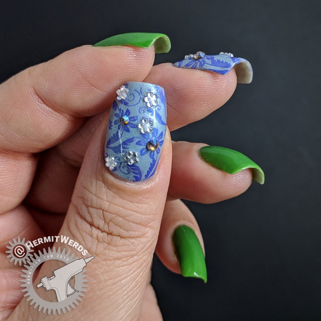 Floral nail art featuring Pantone's Eden and blue floral accent nails with rhinestones.