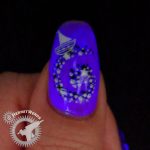 Dreamy purple glow in the dark nail art with a child stargazing on the back of a whale.