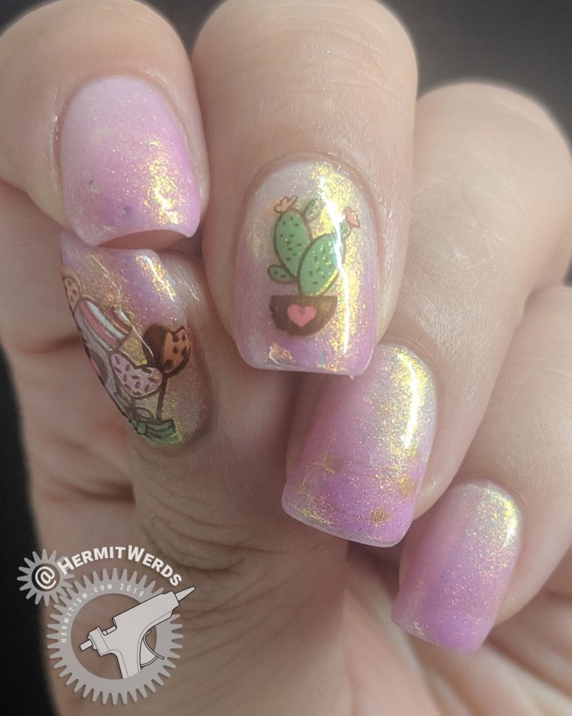 Pink and white thermal mani with adorable heart and cactus nail decals and gold shimmer.