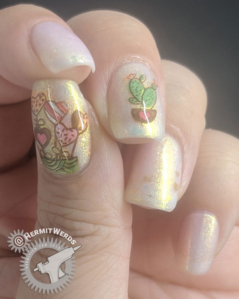 Pink and white thermal mani with adorable heart and cactus nail decals and gold shimmer.