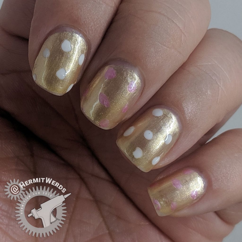 Simple gold mani with pink and white polka dots.
