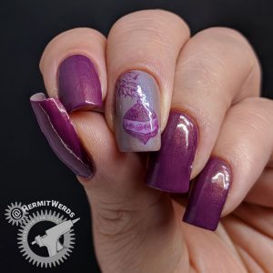 Purple nail art with an ornament hanging from a Christmas tree stamping decal.