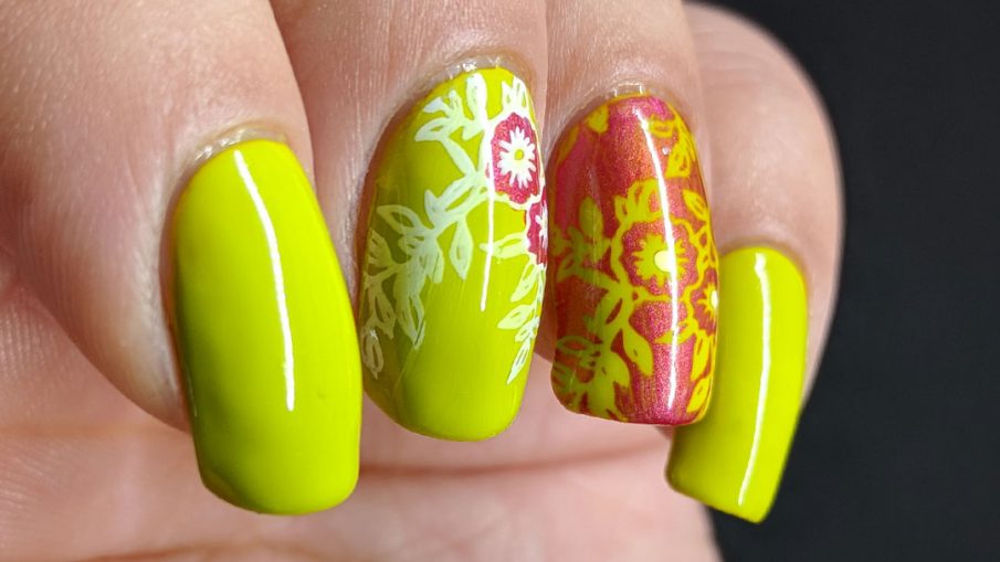 Bright green nail art with floral nail stamping in pink and white.