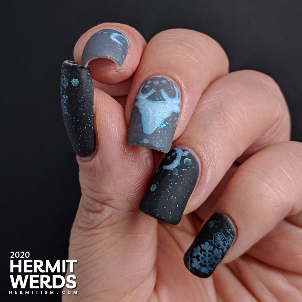 Cold, dark nail art with black and grey crellies filled with aqua hex glitter and the frosty white spirit of a deer.