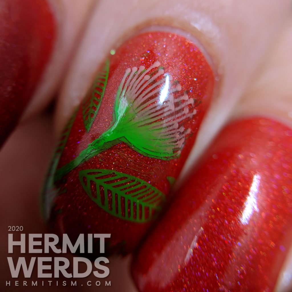 Tomato red nail art with bright green and pink stamped floral and leaf patterns.