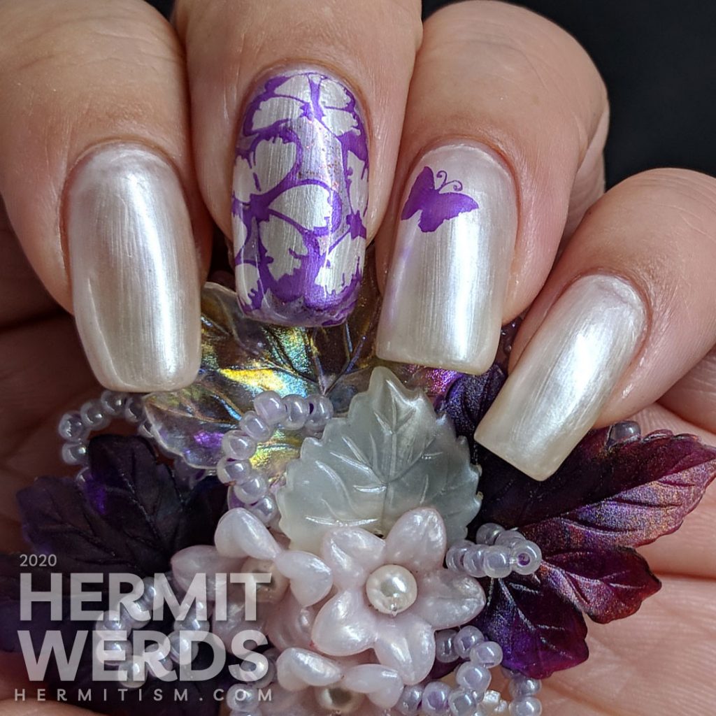 Pearly white/pink sun-activated nail art with purple butterfly stamping.