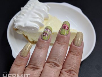 Pi Day nail art with a cream colored background π symbols and pie-related stamping decals.