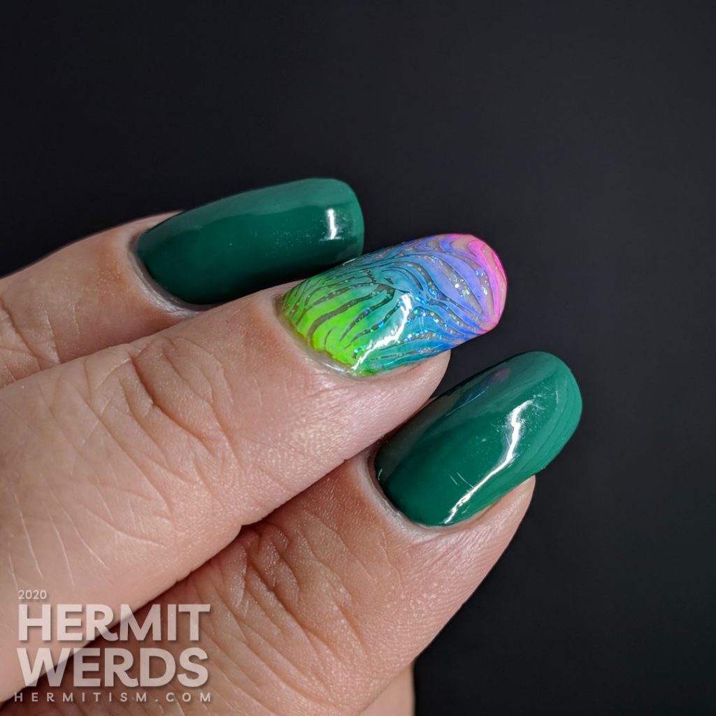 Green nail art with a rainbow zebra accent nail.