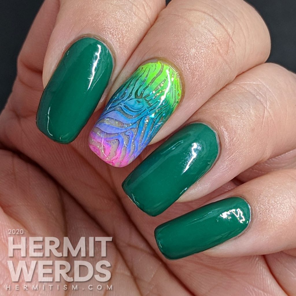 Green nail art with a rainbow zebra accent nail.