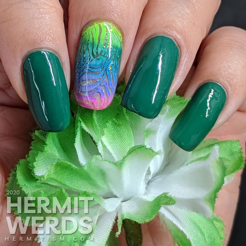 Green nail art with a rainbow zebra accent nail.