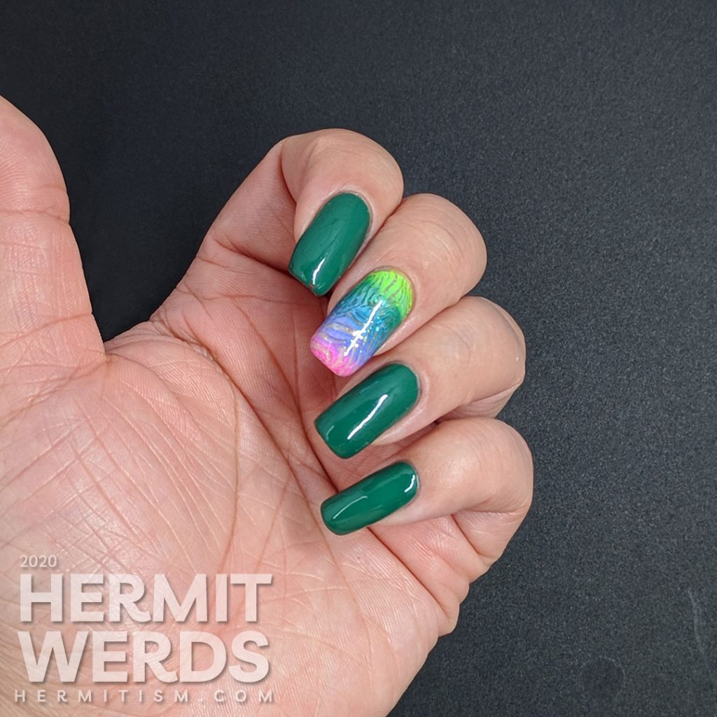 Green nail art with a rainbow zebra accent nail.