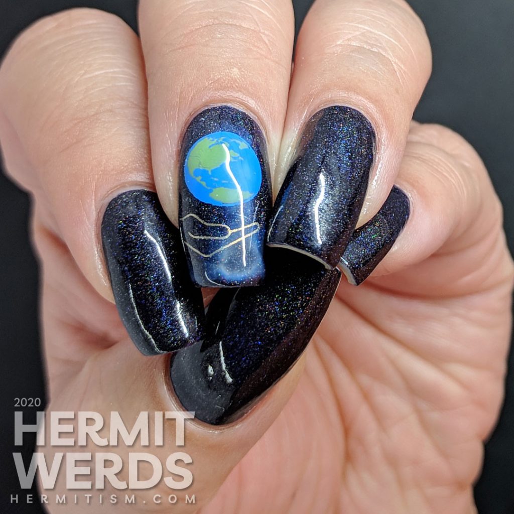 Holographic Earth Day nail art of the Earth being cradled in a human hand.