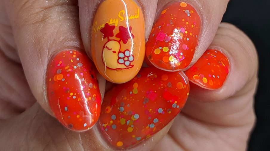 Cute little flower-shelled snail paired with a bright orange to nude crelly polish packed with colorful glitter.