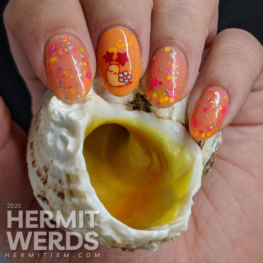 Cute little flower-shelled snail paired with a bright orange to nude crelly polish packed with colorful glitter.