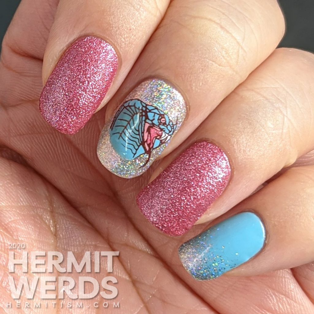 A soft pink and blue nail art decorated with hooded cobra stamping decals and a little dash of the holographic.