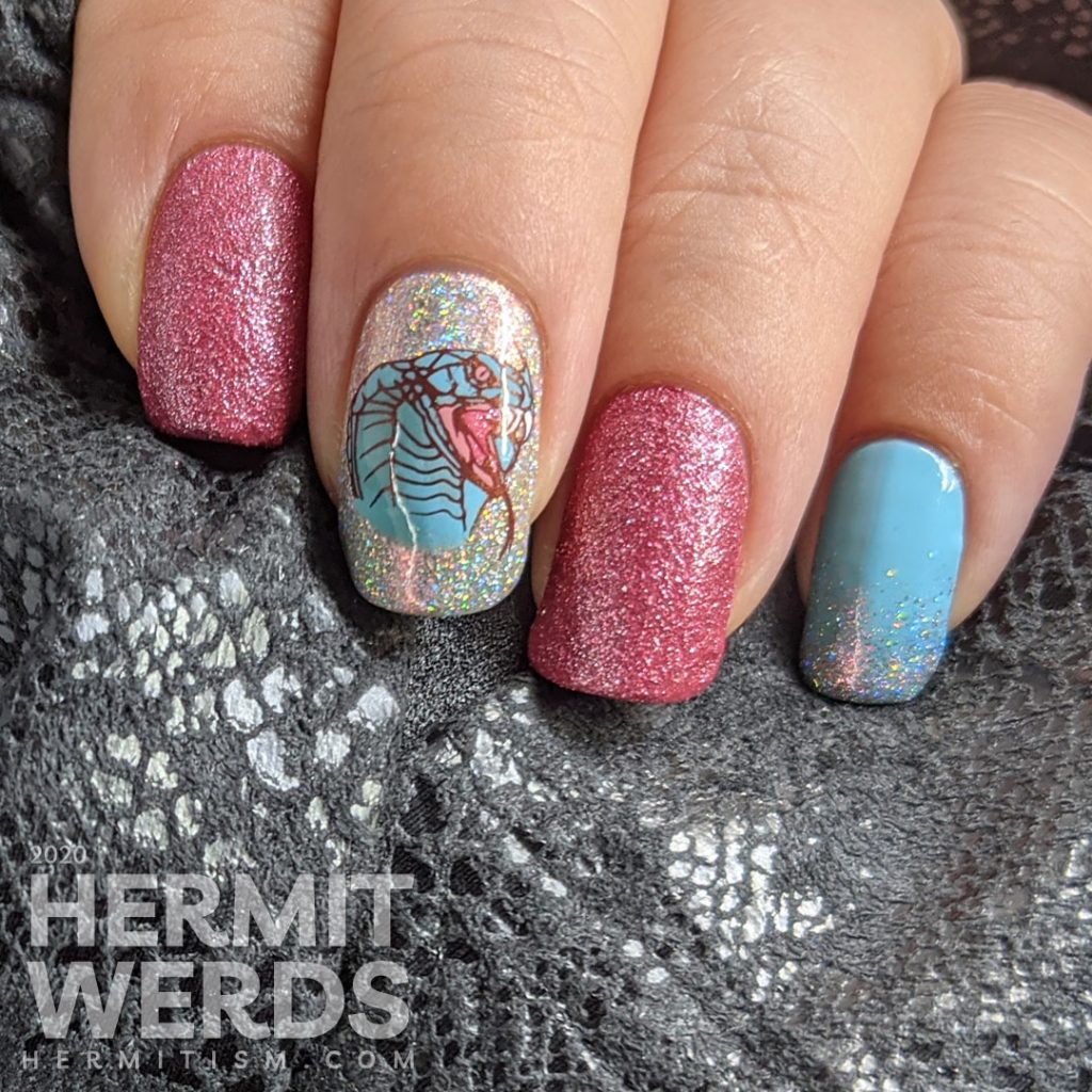 A soft pink and blue nail art decorated with hooded cobra stamping decals and a little dash of the holographic.