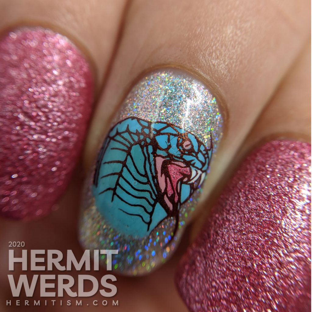 A soft pink and blue nail art decorated with hooded cobra stamping decals and a little dash of the holographic.