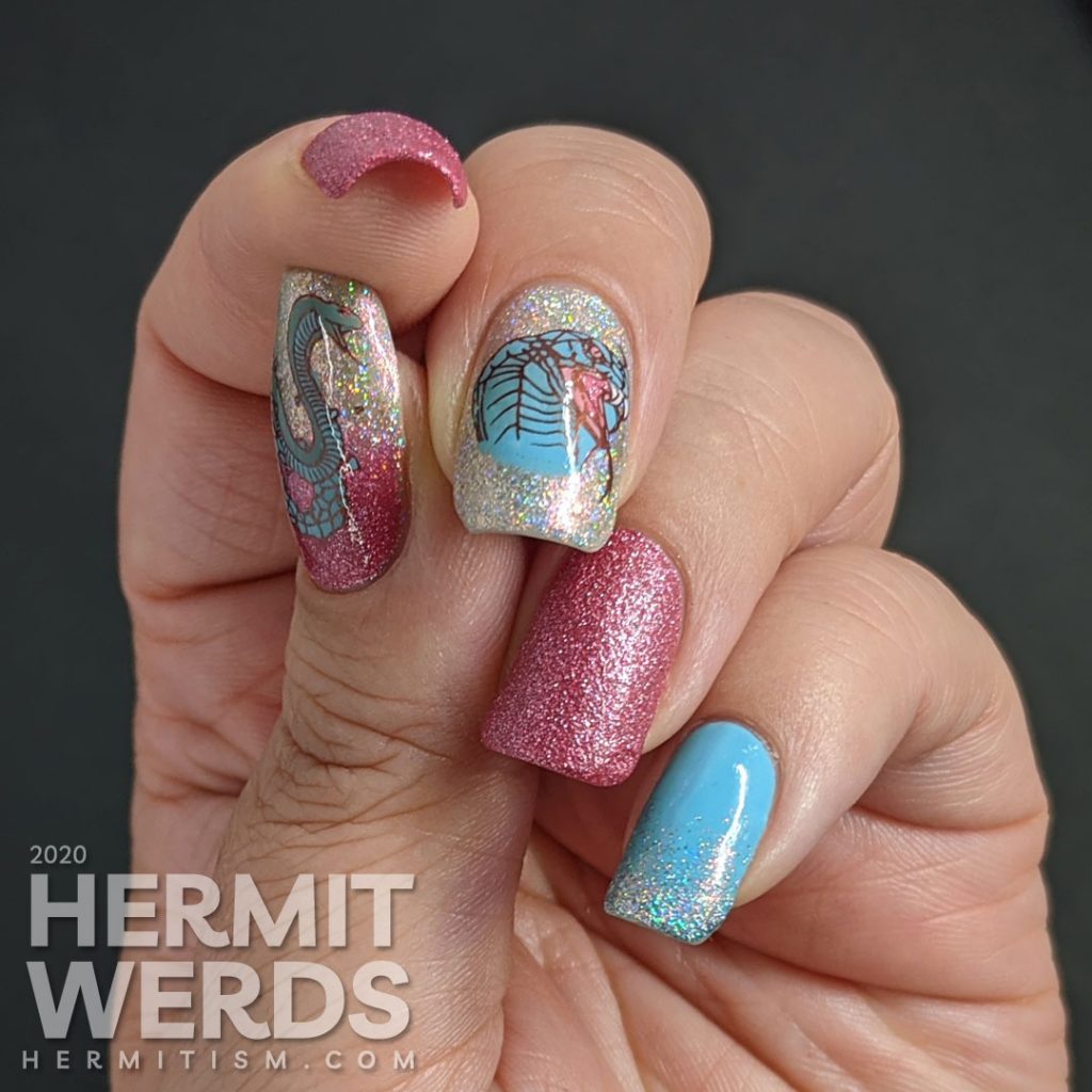 A soft pink and blue nail art decorated with hooded cobra stamping decals and a little dash of the holographic.