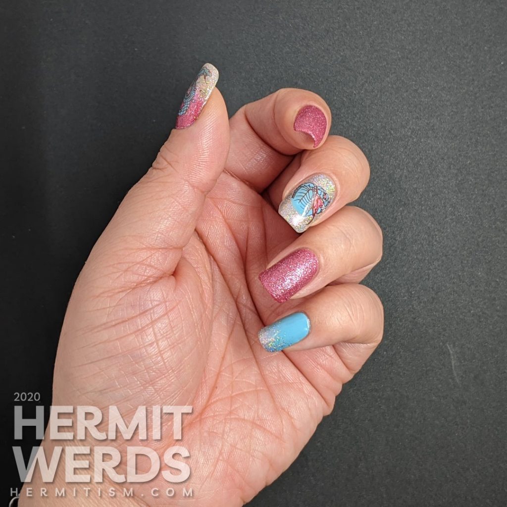 A soft pink and blue nail art decorated with hooded cobra stamping decals and a little dash of the holographic.