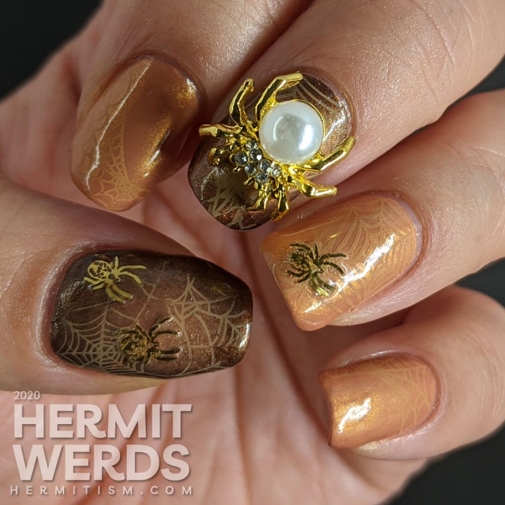 Elegant golden brown nail art with spider web stamping, small metal spider sequins, and a large pearl spider nail charm.