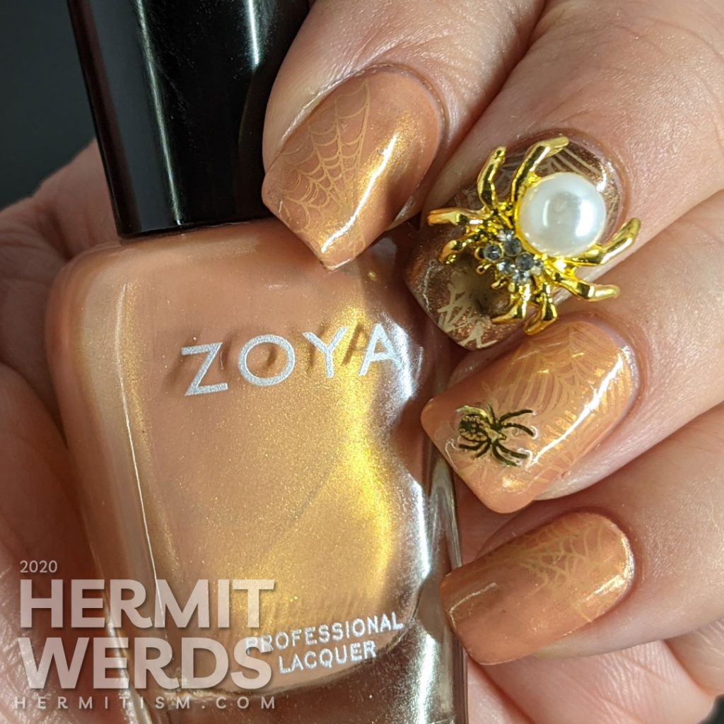 Elegant golden brown nail art with spider web stamping, small metal spider sequins, and a large pearl spider nail charm.