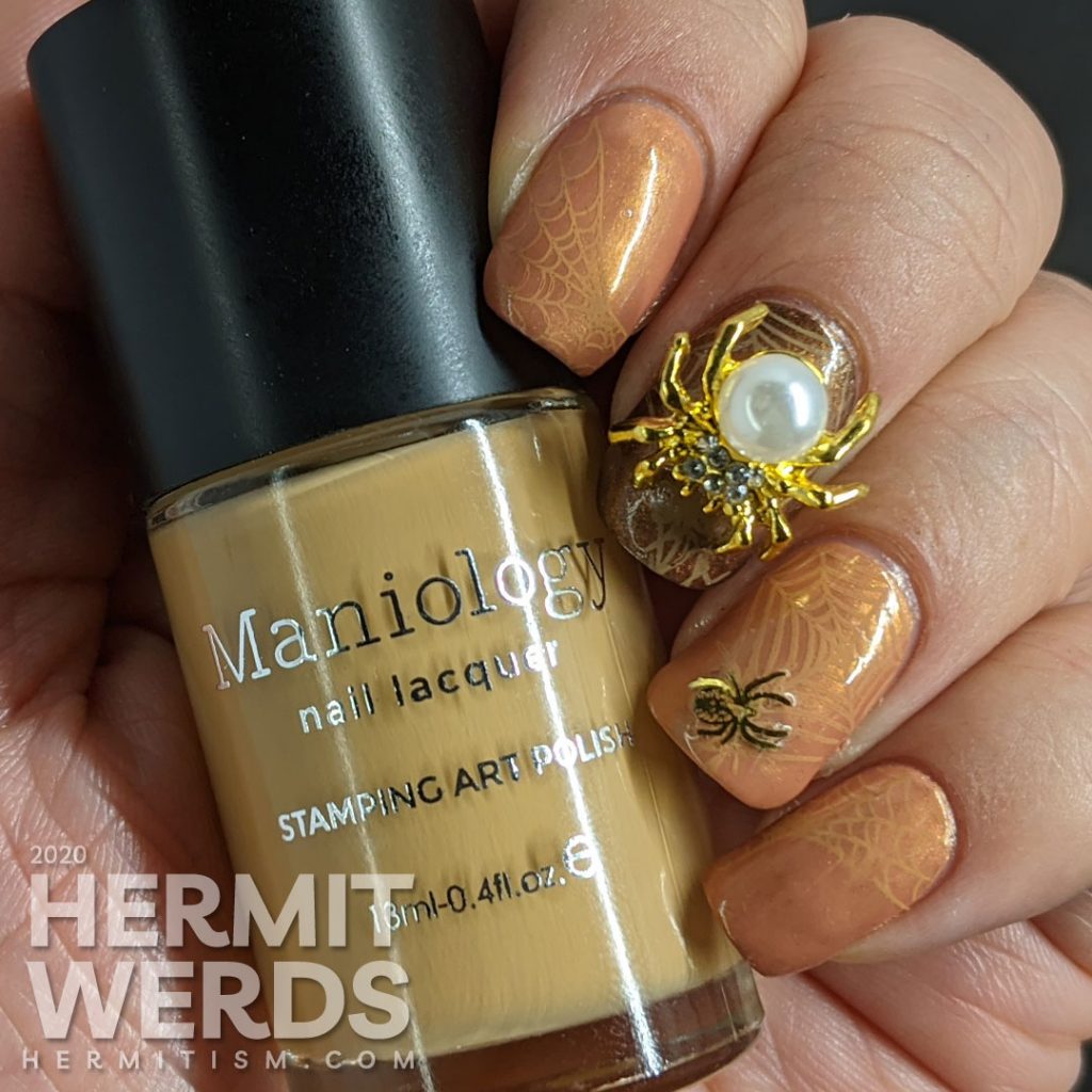 Elegant golden brown nail art with spider web stamping, small metal spider sequins, and a large pearl spider nail charm.