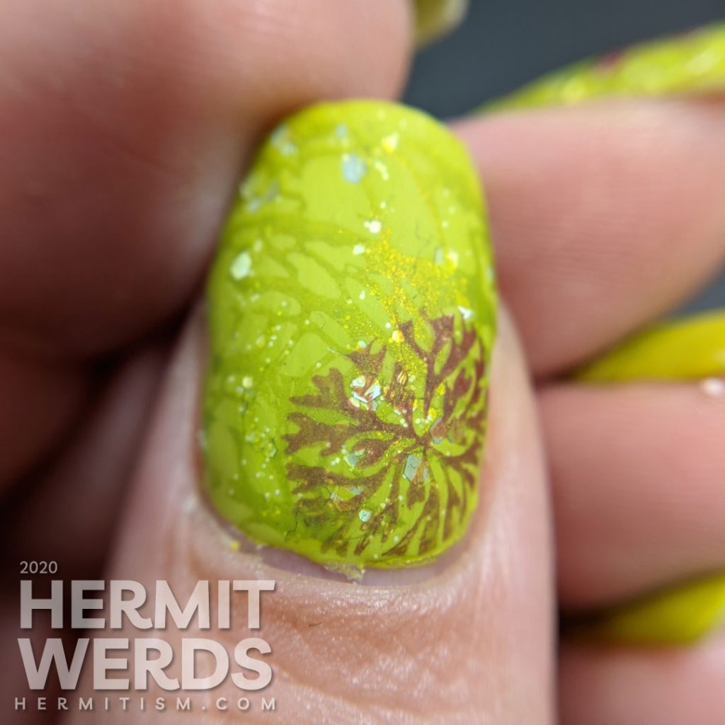 Bright celery green nail art with a skull and crossed swords stamped on top.