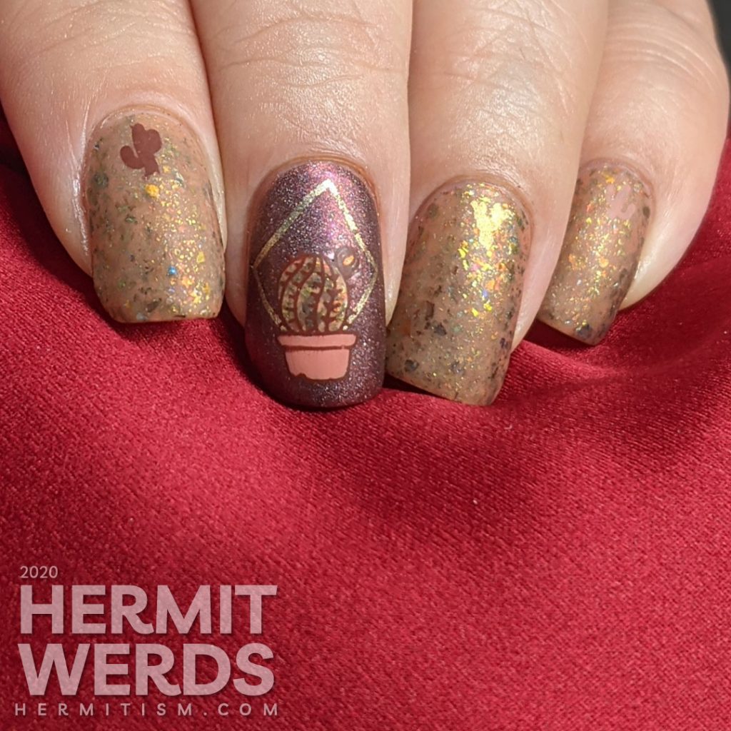 Cactus-themed nail art with a tawny brown and holographic dark red polish and gold geometric frames with potted cacti.