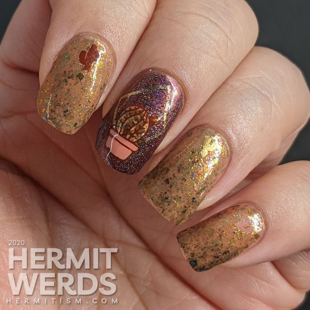 Cactus-themed nail art with a tawny brown and holographic dark red polish and gold geometric frames with potted cacti.