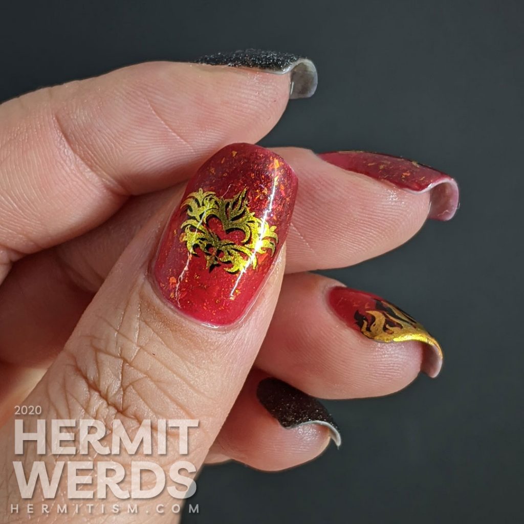 A glow in the dark fire-y thermal red and black nail art with double stamped scorpion and flames and edgy black textured polish accent nails.