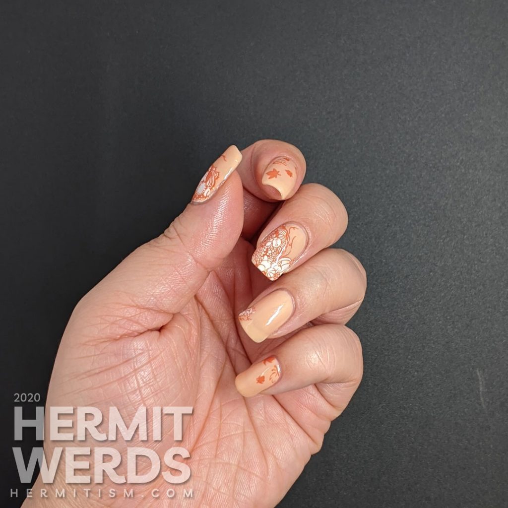 A simple fall nail art with stampings of leaves, pumpkins, and other harvest-related items on an apricot jelly polish background.